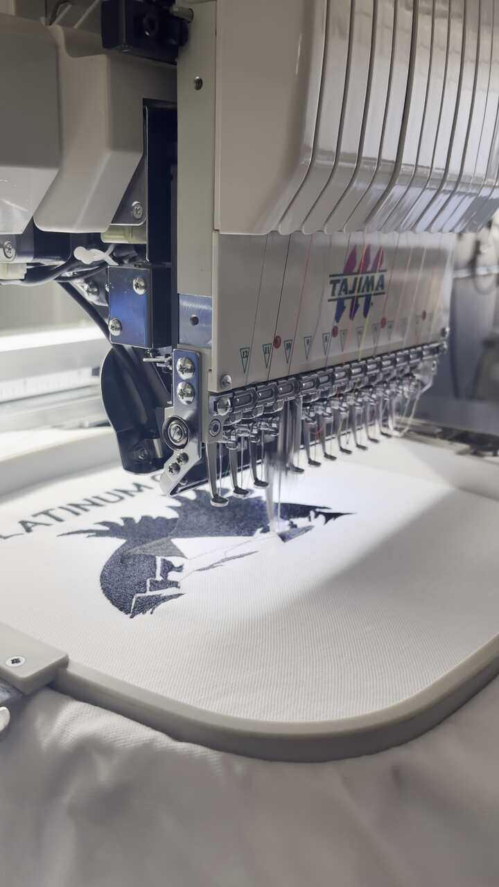 Embroidery machine stitching a logo onto a garment at the HomeLand factory